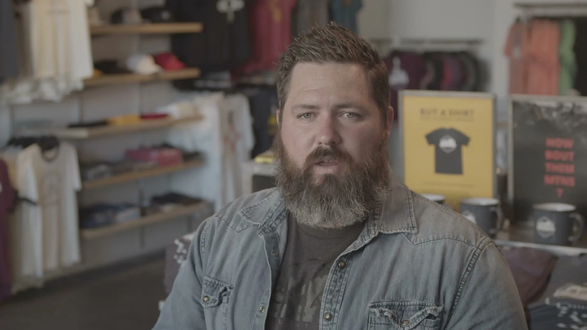 The Organ Mountain Outfitters founder speaking in a shop with products behind him.